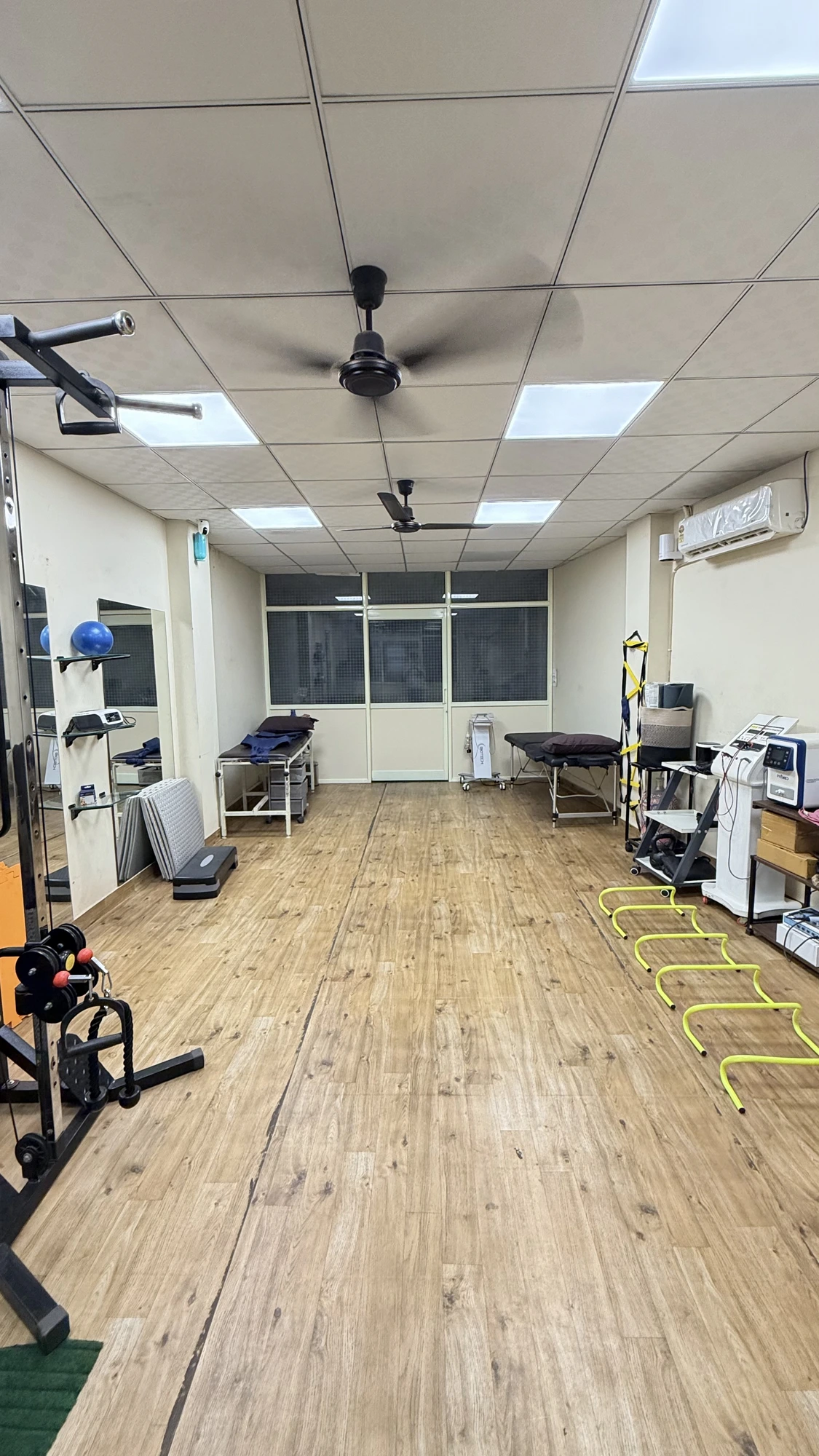 Rehabilitation gym at Physio Hyve Clinic with agility ladders, cable machine and treatment couches